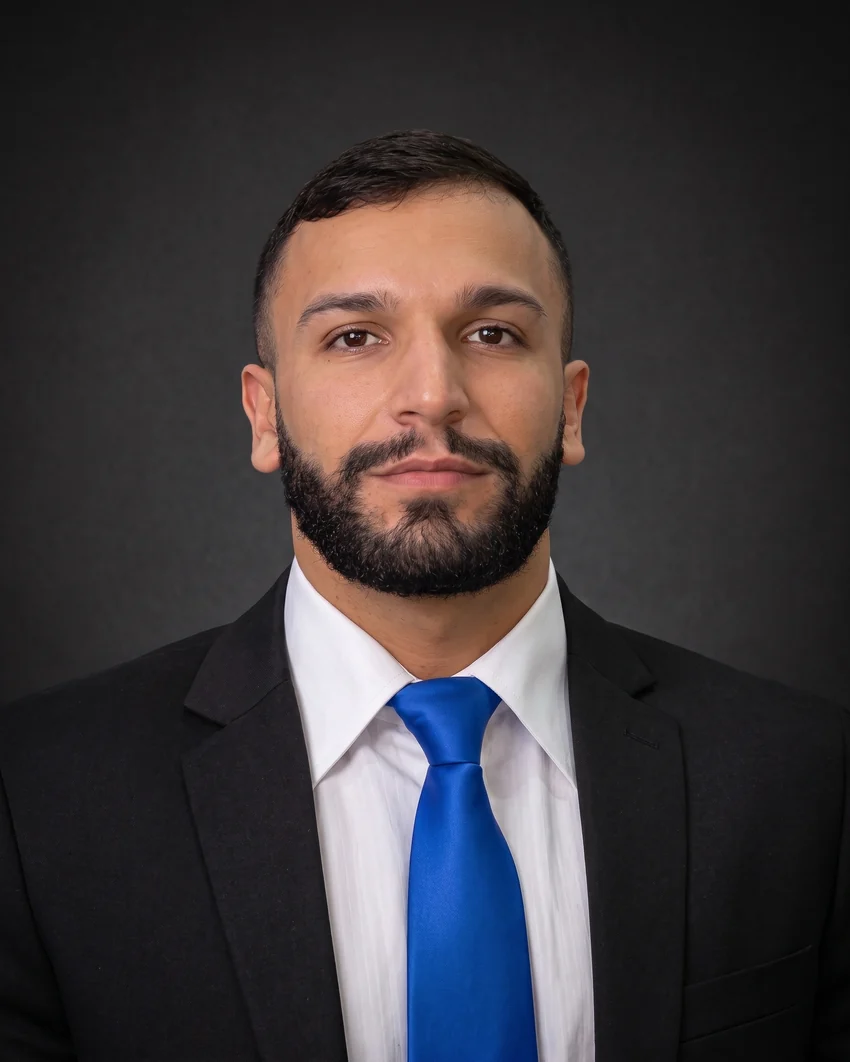 Ruan Pontes em retrato de estúdio, de terno escuro e gravata azul